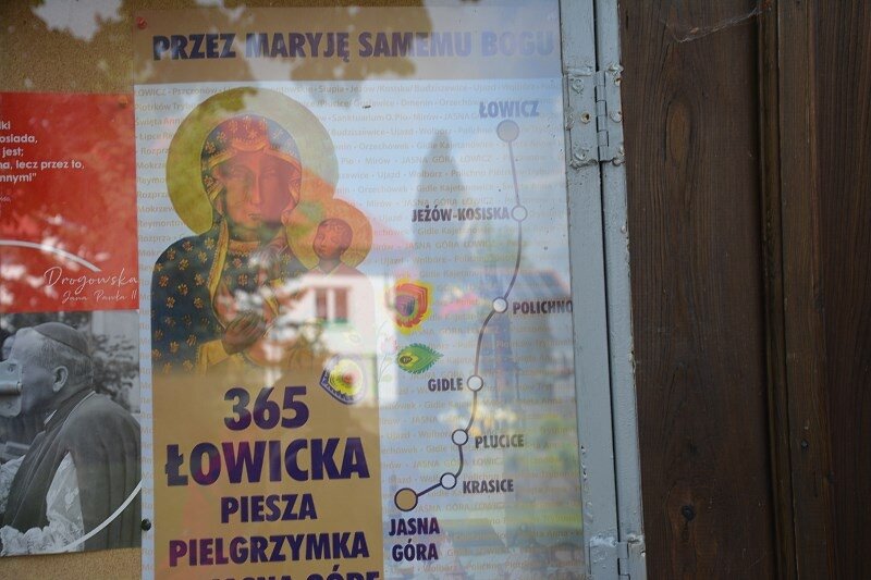 Kilkaset metrów dalej jest drewniany kościółek. W gablocie wisi plakat informujący o Łowickiej Pielgrzymce. 